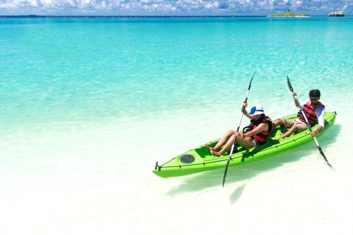 a man in a green boat on a body of water